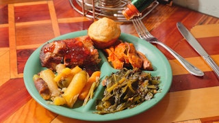 Hal and Mals plate lunch on wooden table with hot sauce