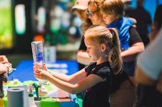 child conducting experiment science museum MMNS